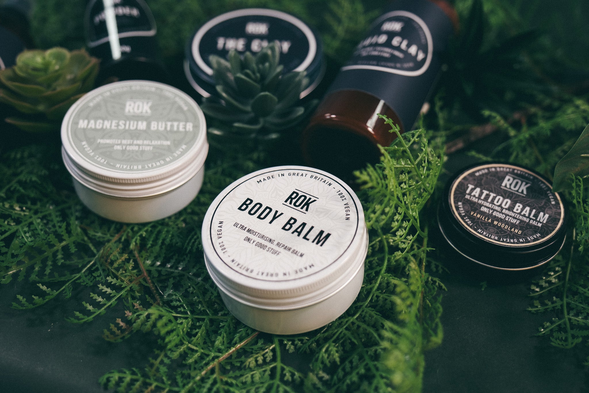 Full ROK Products skincare range on green fern – Body Balm, Magnesium Butter, Tattoo Balm, Liquid Clay and The Clay