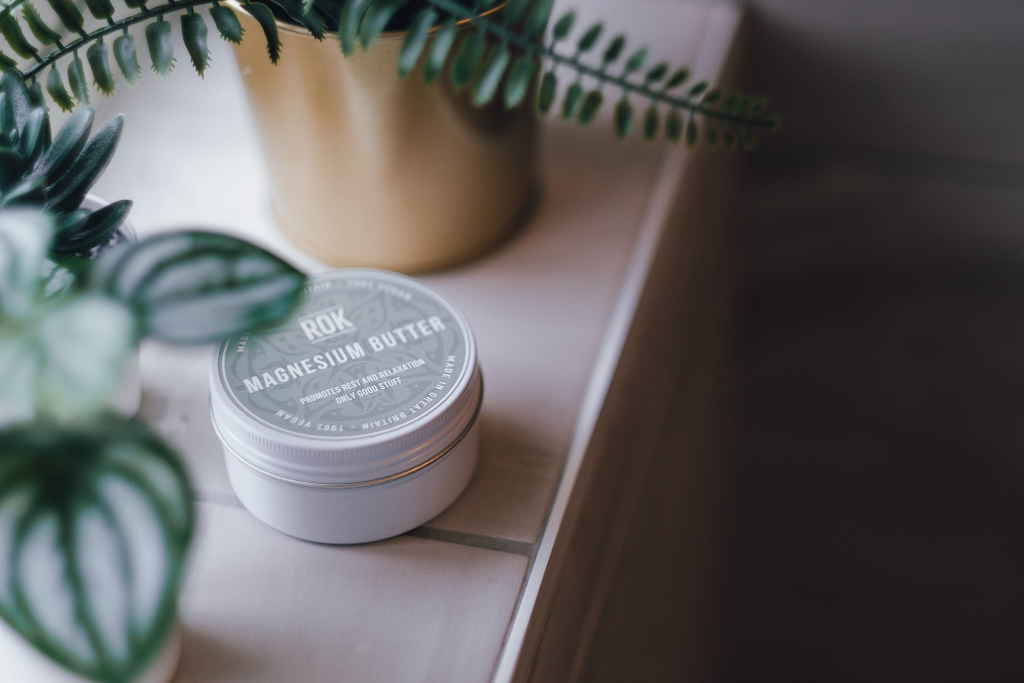 ROK Magnesium Butter jar on wooden surface with plants – natural body butter UK made