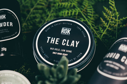 ROK The Clay puck with other ROK hair products and green foliage – vegan hair styling range