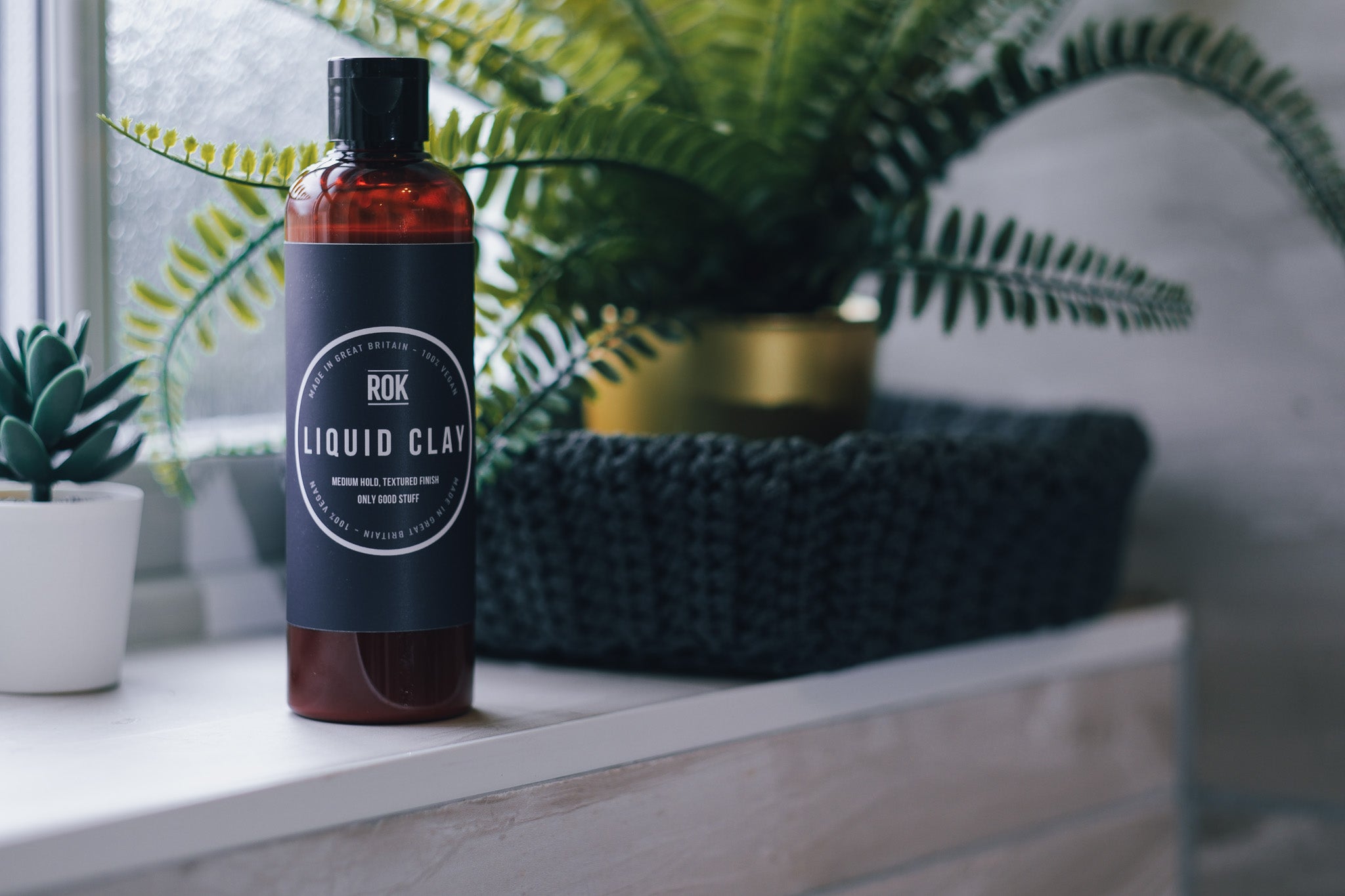 ROK Liquid Clay bottle on shelf with fern and succulent plant background – vegan UK hair product