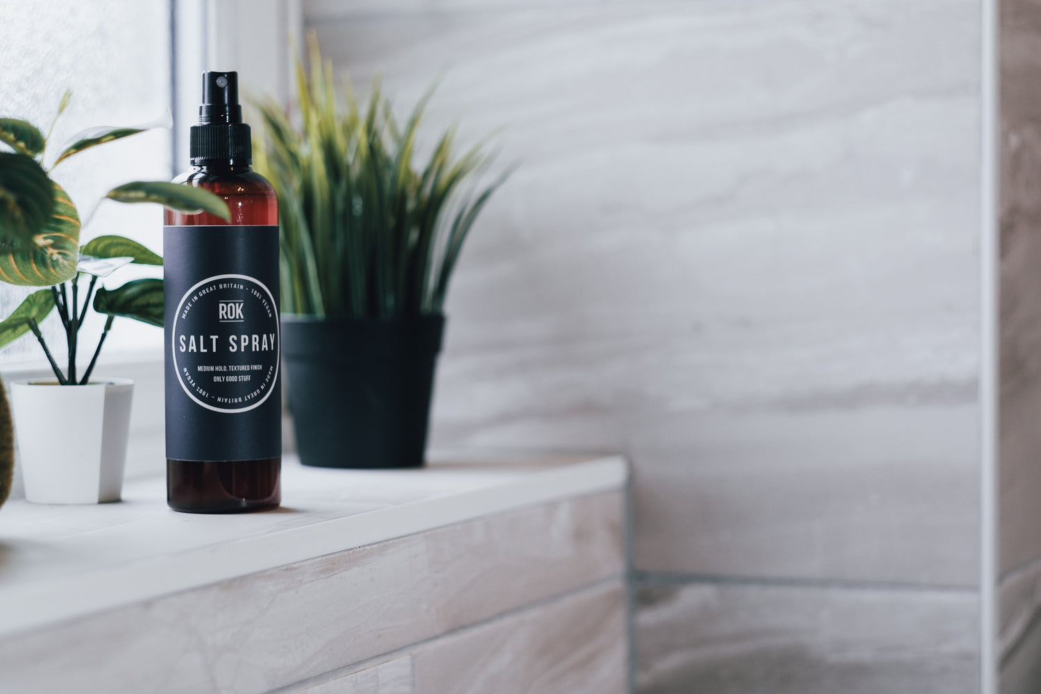 ROK Salt Spray bottle on bathroom shelf with potted plants – sea salt wave spray for hair
